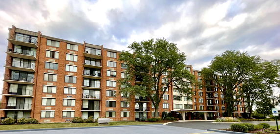 Front view of a multi-story apartment building with balconies.