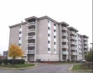 Front view of a multi-story apartment building with balconies.