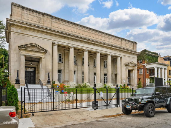 Front view of a large building with columns and multiple entrances.