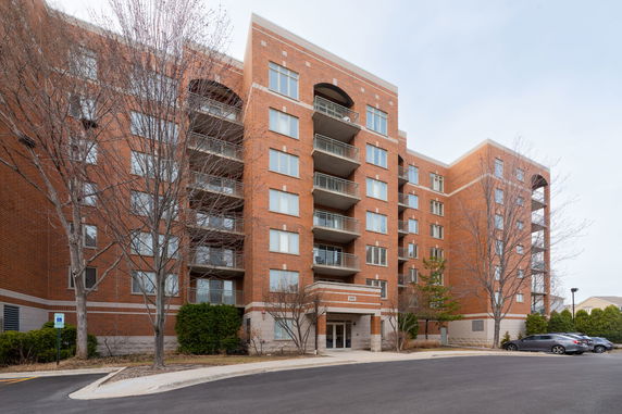 Front view of a multi-story brick apartment building with balconies.