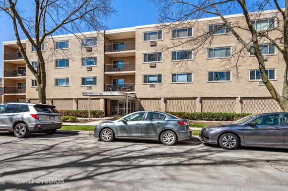 Front view of a multi-story residential building with balconies and a brick exterior.