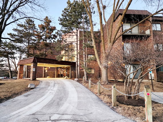 Front view of a multi-story brick building with a covered entrance.