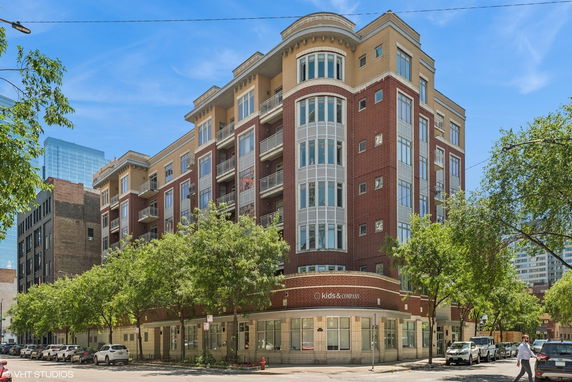 Front view of a multi-story building with a brick facade and large windows.
