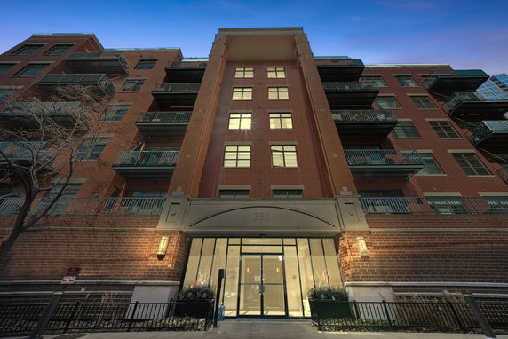 Front view of a multi-story brick building with balconies.