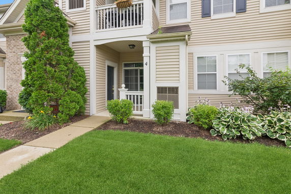 Front view of a house with a small porch and a garden.
