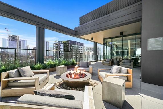 Rooftop seating area with armchairs and a central fire pit.