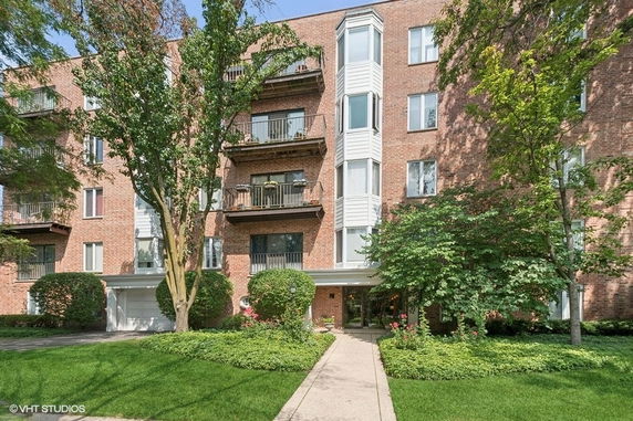 Front view of a multi-story brick residential building with balconies.