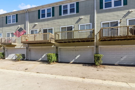 Front view of a multi-story house with a double garage and balconies.