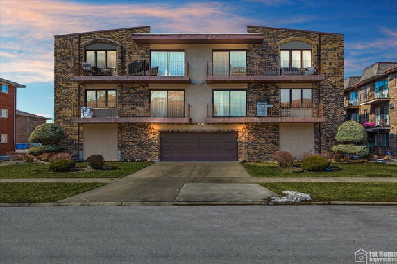 Front view of a three-story apartment building with balconies.