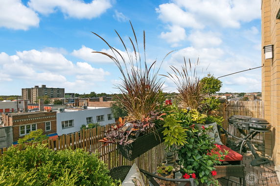 Rooftop with plants and outdoor seating area.