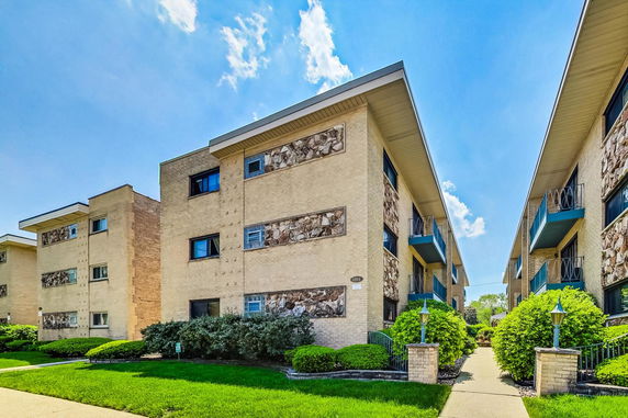 Front view of a multi-story apartment building with balconies.
