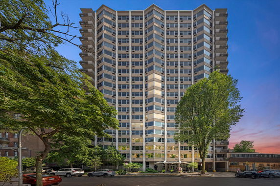 Front view of a tall, multi-story building with numerous windows and balconies.