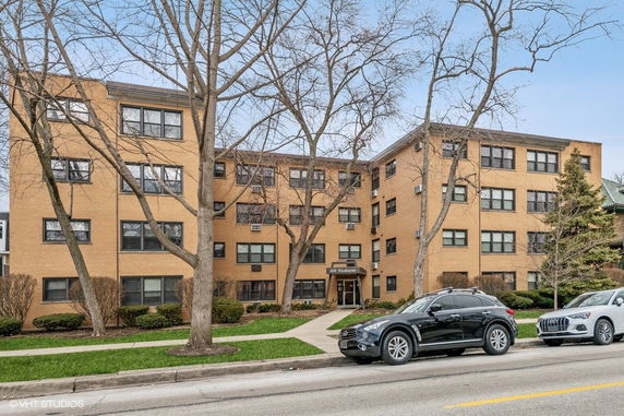 Front view of a multi-story apartment building with brick exterior.