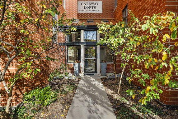 Front view of a loft building entrance with brick exterior and glass door.
