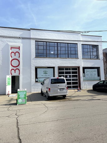 Front view of a two-story building with large windows and a garage door.