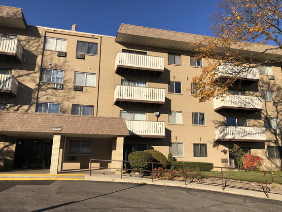 Front view of a multi-story apartment building with balconies.