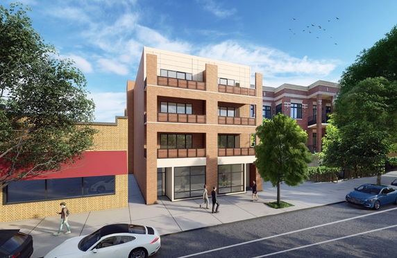Front view of a modern three-story brick building with large windows and balconies.