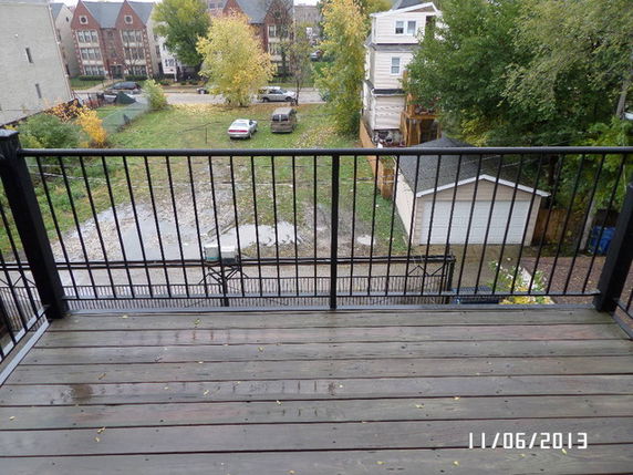 View from a deck overlooking a yard with a small garage and surrounding neighborhood.
