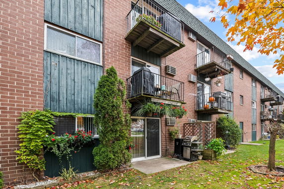 Front view of a multi-story brick apartment building with balconies.