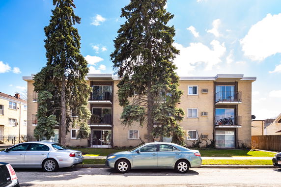 Front view of a three-story apartment building with balconies.