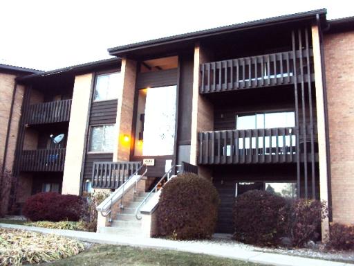 Front view of a multi-story apartment building with balconies and a central entrance.