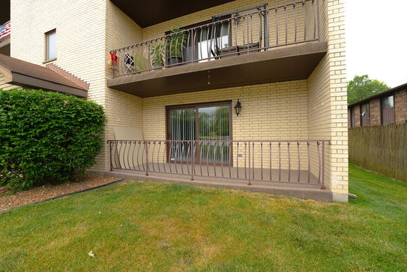 Front view of a building with two balconies and brick exterior.