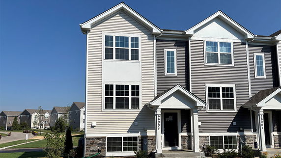 Front view of a multi-story residential building with gabled roofs.
