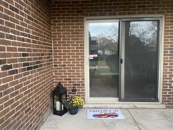 Front view of a house with a sliding glass door and brick exterior.
