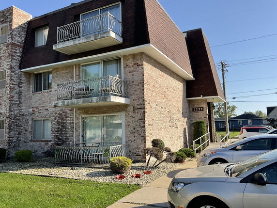 Front view of a multi-story brick building with balconies.
