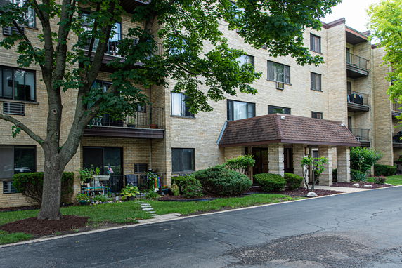 Front view of a multi-story apartment building with balconies and a main entrance.