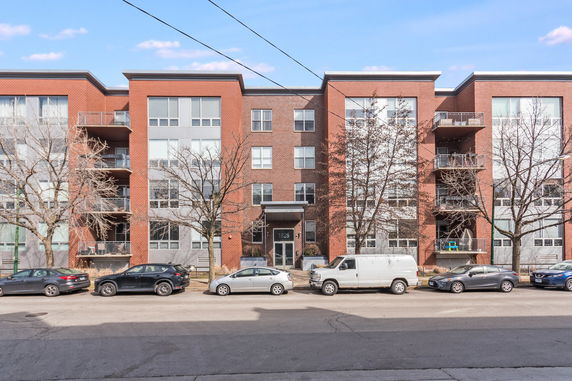 Front view of a multi-story brick apartment building.