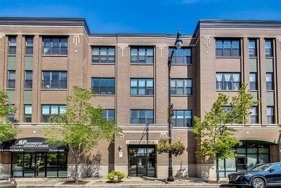 Front view of a multi-story brick building with multiple windows.