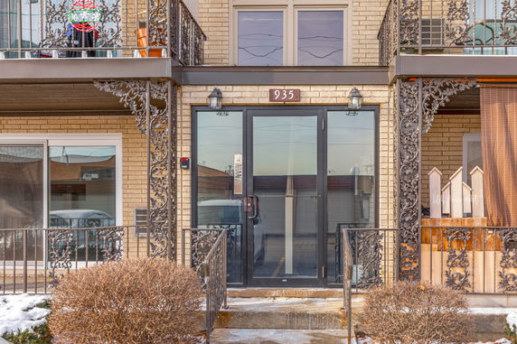 Front view of a building entrance with decorative iron railings.