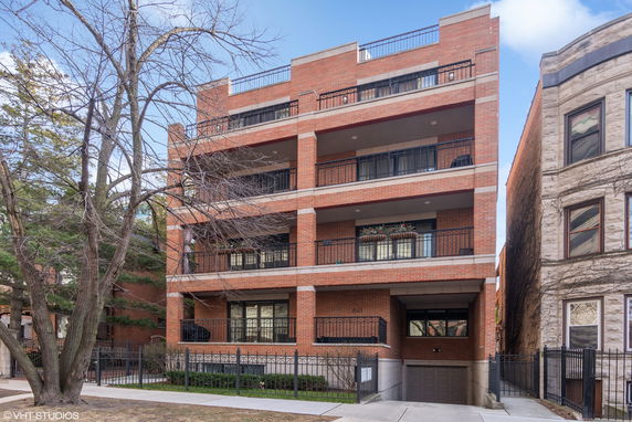 Front view of a multi-story brick building with balconies on each floor.