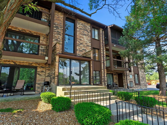 Front view of a multi-story brick apartment building with balconies.