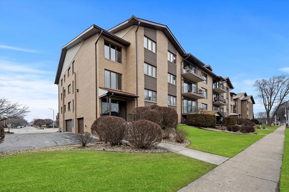 Front view of a multi-story apartment building with balconies.