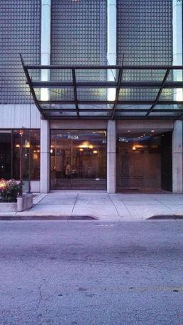 Front view of a building with a glass canopy entrance.