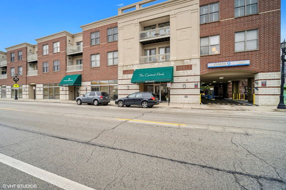 Front view of a multi-story building with shops on the ground floor and residential units above.