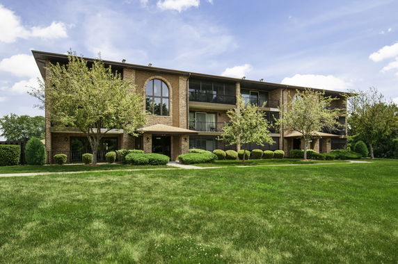 Front view of a three-story apartment building with balconies.