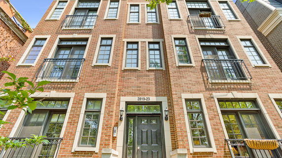 Front view of a multi-story brick building with numerous windows.