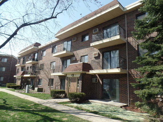 Front view of a multi-story apartment building with balconies.