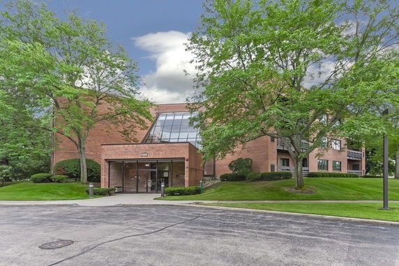 Front view of a large brick building with glass entrance.