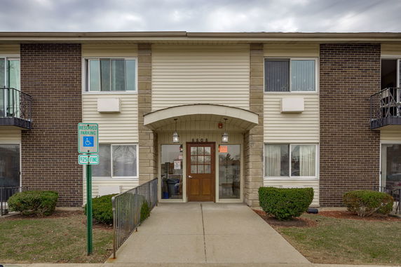 Front view of a two-story building with a brick and siding exterior and a central entrance.