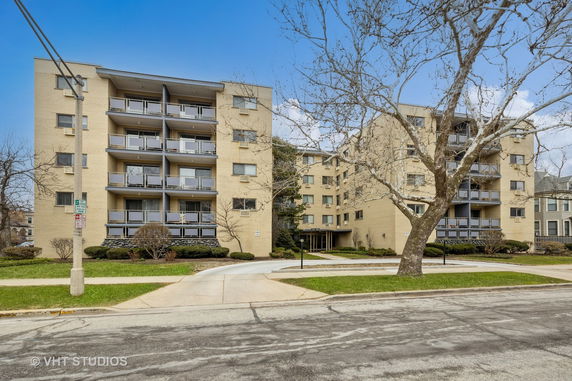 Front view of a multi-story apartment building with balconies.
