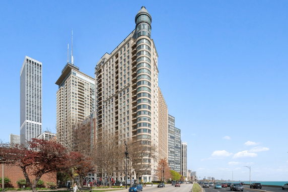 Front view of a high-rise building with a rounded corner and numerous windows.