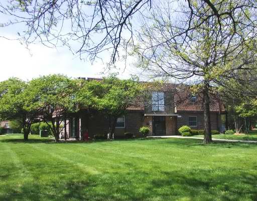 Front view of a two-story house with brick exterior and large windows.