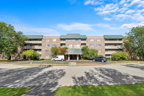 Front view of a multi-story residential building with a green roof.