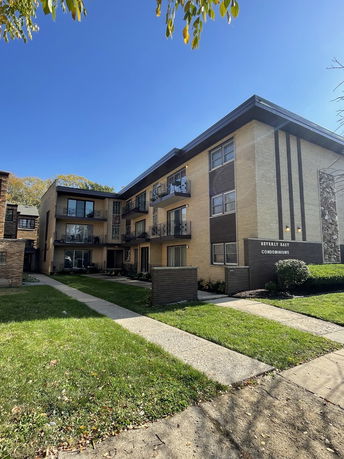 Front view of a multi-story condominium building with balconies.