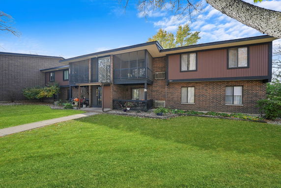 Front view of a two-story brick apartment building with balconies.