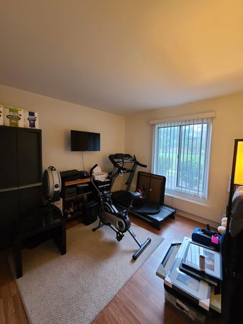 Indoor room with exercise equipment like a stationary bike and a treadmill.